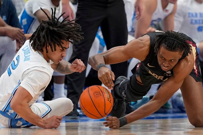North Carolina guard Elliot Cadeau, left, and Florida State forward Jaylan Gainey lunge for a loose ball during the first half of an NCAA college basketball game in the quarterfinal round of the Atlantic Coast Conference tournament Thursday, March 14, 2024, in Washington. (AP Photo/Susan Walsh)