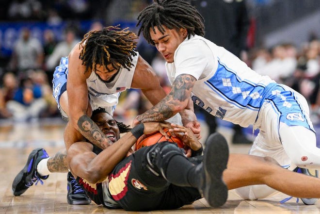 Florida State forward Jaylan Gainey, center, and North Carolina guards Elliot Cadeau, top left, and RJ Davis, top right, go for the ball during the first half of an NCAA college basketball game in the quarterfinal round of the Atlantic Coast Conference tournament Thursday, March 14, 2024, in Washington. (AP Photo/Nick Wass)