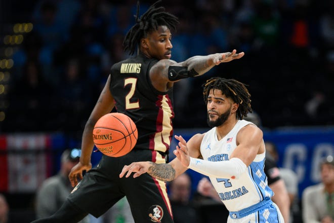 North Carolina guard RJ Davis, right, passes the ball past Florida State forward Jamir Watkins during the first half of the Atlantic Coast Conference quarterfinals NCAA college basketball tournament game Thursday, March 14, 2024, in Washington. (AP Photo/Nick Wass)