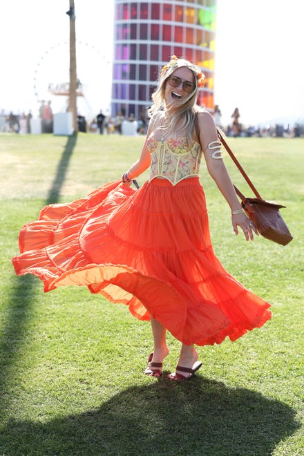 Boho chic in a corset top paired with a tiered orange skirt.