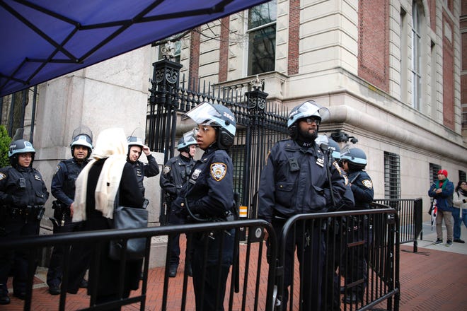 NYPD Officers stand guard by one of the gates of Columbia University in New York City on April 18, 2024. Officers cleared out a pro-Palestinian campus demonstration on April 18, a day after university officials testified about anti-Semitism before Congress. Leaders of Columbia University defended the prestigious New York school's efforts to combat anti-Semitism on campus at a fiery congressional hearing on April 17.