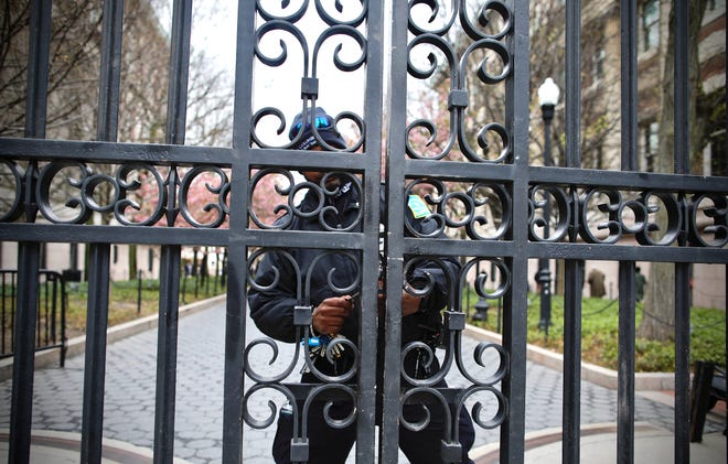 A guard unlocks one of the gates of Columbia University in New York City on April 18, 2024. NYPD Officers cleared out a pro-Palestinian campus demonstration on April 18, a day after university officials testified about anti-Semitism before Congress. Leaders of Columbia University defended the prestigious New York school's efforts to combat anti-Semitism on campus at a fiery congressional hearing on April 17.
