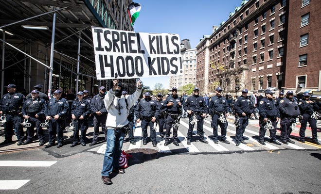 An anti-Israel protestor stands in front of dozens of New York City police officers across the street from Columbia University in Manhattan April 22, 2024.