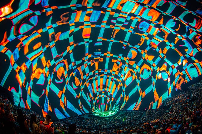 Phish made clever use of the surroundings, whether mesmerizing with repetitive swirls of shapes or sending lighted fabric pods toward the roof during the ethereal ÒLeaves.Ó Floating antenna TVs, silhouettes of the band members in film-negative form, spectacular bursts of color and cars morphing in size and shape complemented songs including "Life Saving Gun" and "Tweezer."