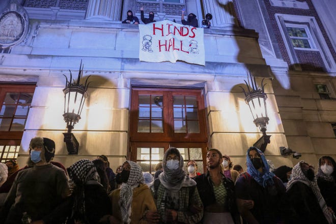 Protesters link arms outside Hamilton Hall barricading students inside the building at Columbia University in New York City on April 30, 2024.