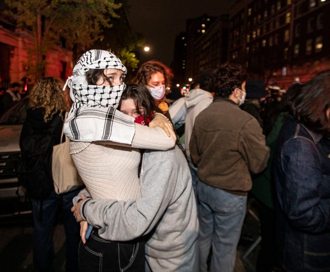 Two people embrace across the street from Columbia University as hundreds of police officers gathered at the university to rid the campus of protesters on April 30, 2024.