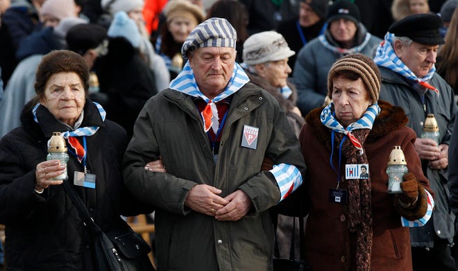 Survivors of Auschwitz arrive at the International Monument to the Victims of Fascism at the former Nazi German concentration and extermination camp KL Auschwitz II-Birkenau walk to place candles on International Holocaust Remembrance Day in Oswiecim, Poland, Sunday, Jan. 27, 2019.
