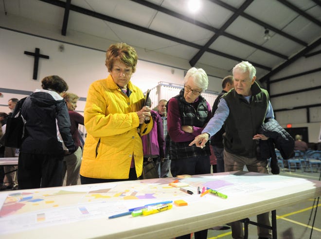 Alderman Maggie Tuttle, left, looks over a map that shows existing land uses on Blue Ridge Road, between the I-40 overpass and N.C. 9, before a small area plan input meeting on March 14.