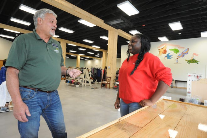 Black Mountain Home for Children President Tom Campbell talks to N'Dia Lee, a resident at the home's independent living program and employee at the Mountain Home Thrifts store. The home will unveil the store, and its Thirteen Pennies Cafe, on Oct. 12.