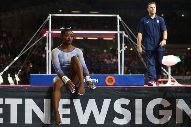 Oct. 5: Simone Biles waits as her coach prepares the uneven bars during the qualifying session at the FIG Artistic Gymnastics World Championships in Stuttgart, Germany.