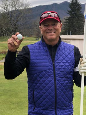 Jerry Hood holds up his ball after achieving a hole-in-one on the third hole at Black Mountain Golf Course.