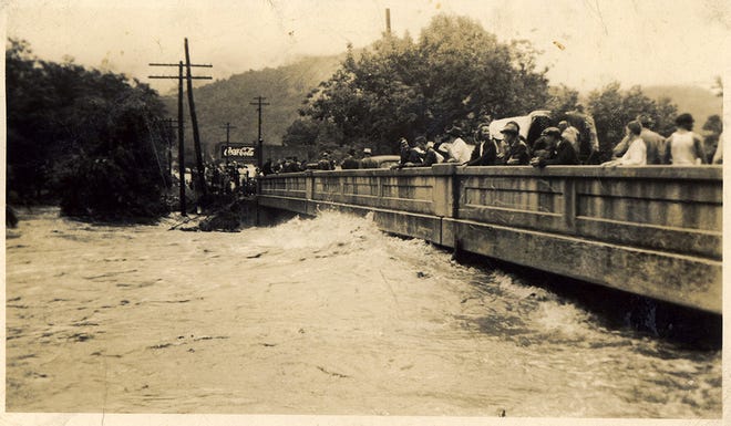 In this photograph from the Swannanoa Valley Museum and History Center's collections, valley residents watch the engorged waters of the Swannanoa River from the Whitson Avenue bridge in Swannanoa during the Great Flood of 1940. The flood was caused by a combination of heavy rain in the early weeks of August 1940 followed by a hurricane that brought additional rainfall for five days. The result was that over 21 inches of rain battered parts of Western North Carolina. According to the Tennessee Valley Authority's publication Floods on French Broad and Swannanoa Rivers (1960), "In the Swannanoa basin [rainfall] amounts ranged from five inches at Asheville to 15 inches on [the] North Fork watershed and 16 inches on upper Bull Creek." The flood caused damage to roadways, bridges, homes, and other infrastructure throughout the valley.