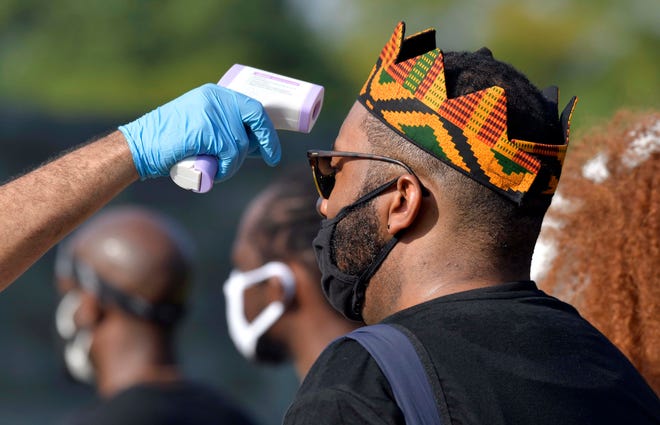 A person has his temperature checked as people gather at the ‘Get Off Our Necks’ Commitment March on Washington.