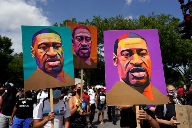 People carry posters with George Floyd on them as they march from the Lincoln Memorial to the Martin Luther King Jr. Memorial during the March on Washington, Friday Aug. 28, 2020, in Washington.
