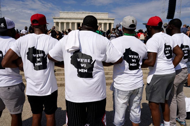 Men from Milwaukee wear "We're WI Men" T-shirts as they attend the March on Washington near the Lincoln Memorial, Friday Aug. 28, 2020, in Washington, on the 57th anniversary of the Rev. Martin Luther King Jr.'s "I Have A Dream" speech.