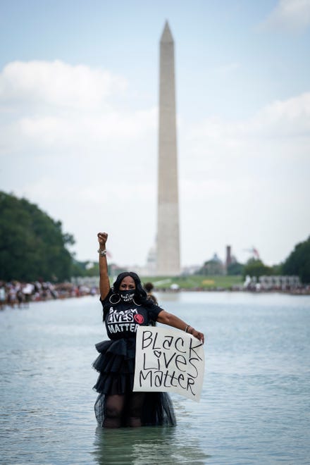 Attendees stand in the reflecting pool near the Lincoln Memorial during the March on Washington August 28, 2020 in Washington, DC. Today marks the 57th anniversary of Rev. Martin Luther King Jr.'s "I Have A Dream" speech at the same location.