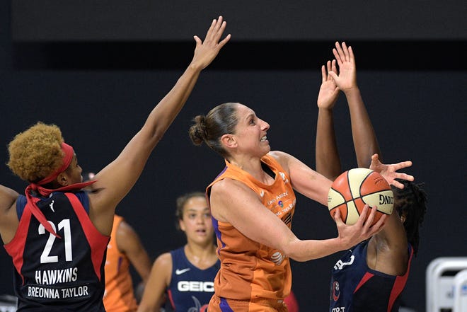 First round: Phoenix Mercury guard Diana Taurasi, center, goes up for a shot between Washington Mystics forward Tianna Hawkins (21) and guard Ariel Atkins, during their single-elimination game on Sept. 15.