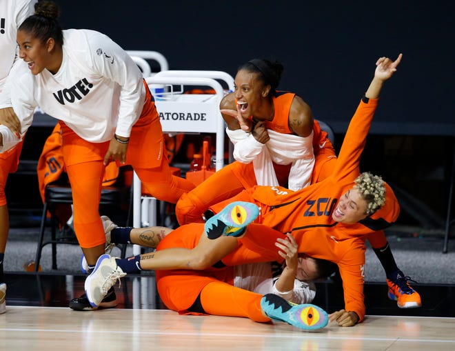 Semifinals: Connecticut Sun guard Natisha Hiedeman falls on forward Theresa Plaisance, bottom, while celebrating with center Brionna Jones, left, and forward DeWanna Bonner during Game 1 of their best-of-five series against the Las Vegas Aces. The Sun won 87-62.